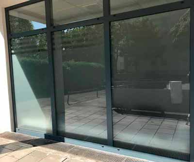 Sicht auf die Glasfassade einer Arztpraxis in München ohne Sonnenschutzfolie