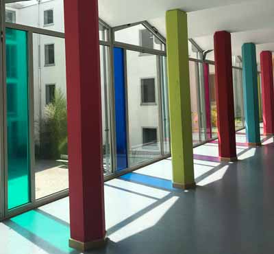 Farbige Glasdekorfolie zur Auflockerung in einem Münchner Gymnasium. Ansicht links.