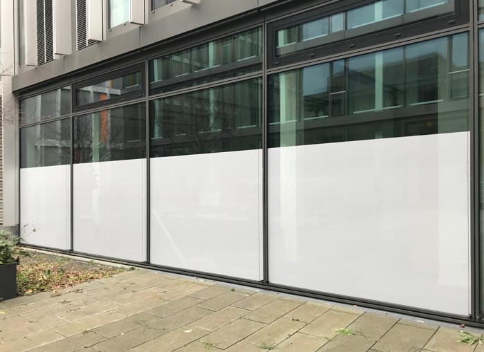 Große Fensterfront im Erdgeschoß mit Lochfolie als Sichtschutzfolie beklebt